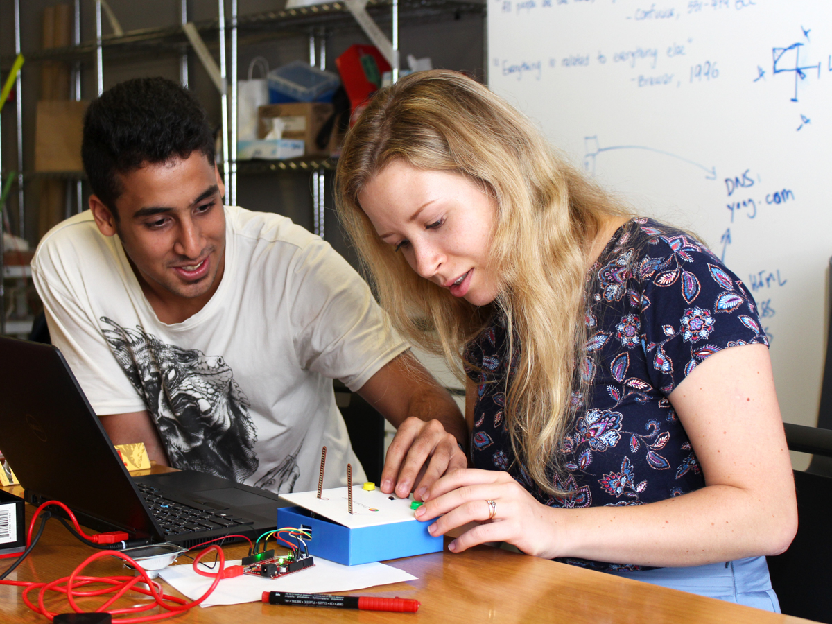 Two students testing an IM musical instrument project